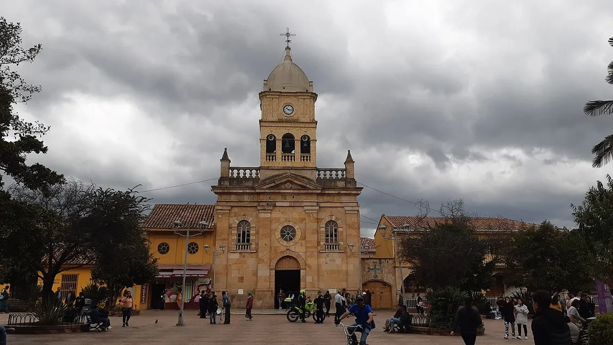 Iglesia de Nuestra Señora del Rosario de La Calera, con torre de reloj y cúpula, en el parque principal