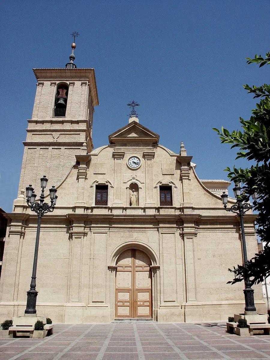 Fachada clara de la iglesia de Nuestra Señora de la Asunción de Molina de Segura, con reloj y campanario