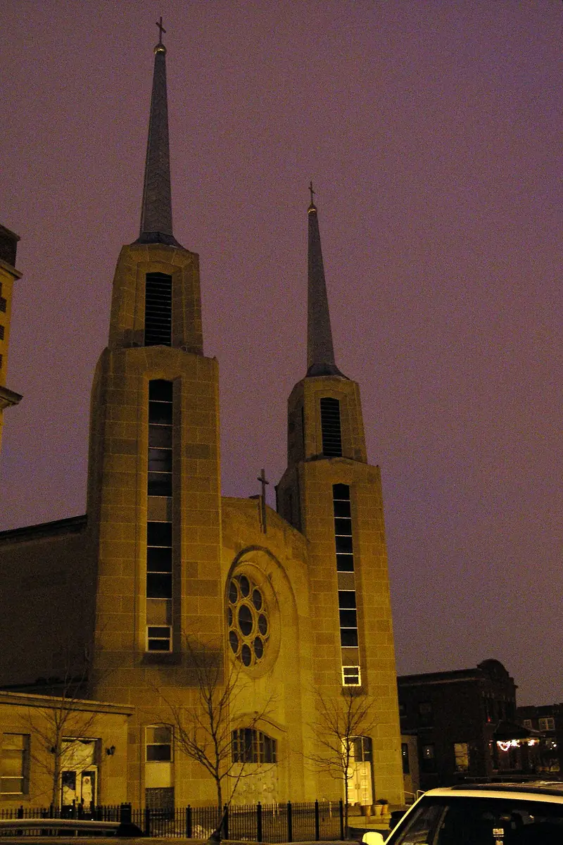 Iglesia Our Lady of Mercy de Chicago, de noche, con sus dos torres iluminadas y el rosetón