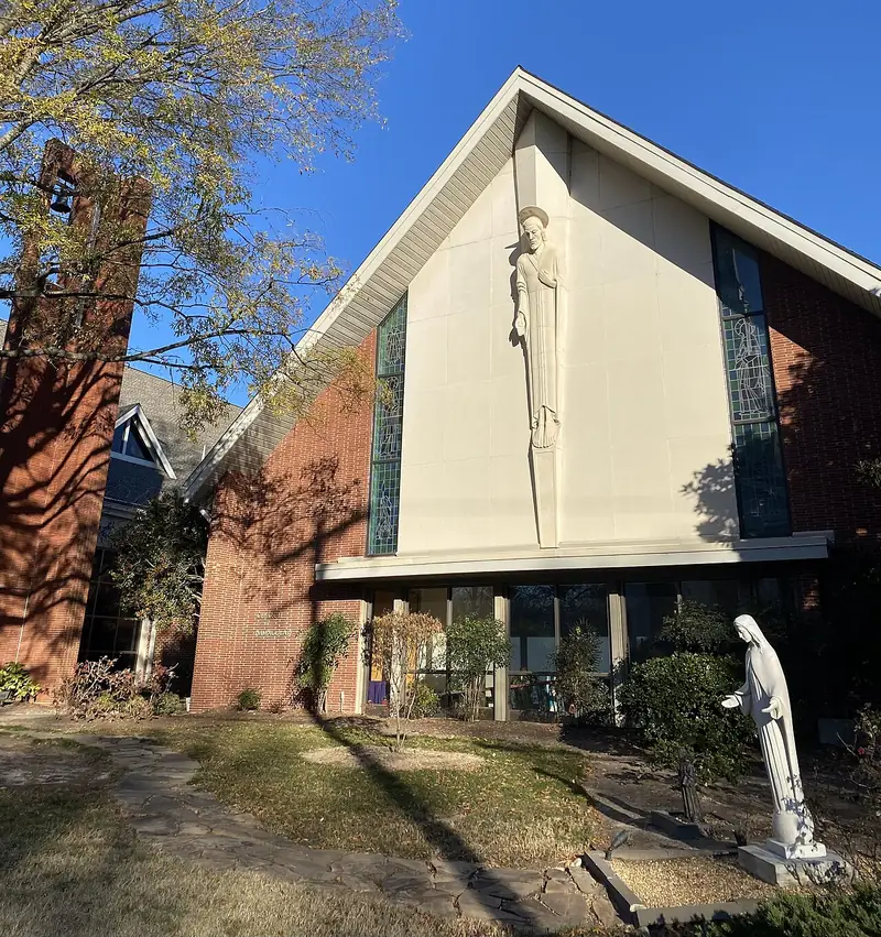 Fachada de la iglesia de la Inmaculada Concepción de Durham, con una alta figura en relieve en el frontón y una imagen de la Virgen en el jardín